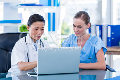 Doctor and nurse looking at laptop