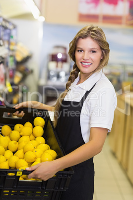 Portrait of a staff woman holding a box with a fresh vegetables