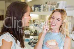 Happy blonde woman applying cosmetic products