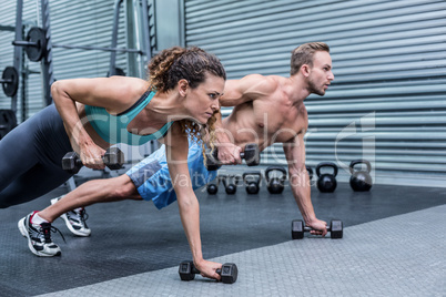 Muscular couple doing plank exercise together