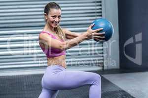 A muscular woman doing ball exercises