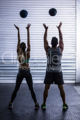 Muscular couple throwing ball in the air