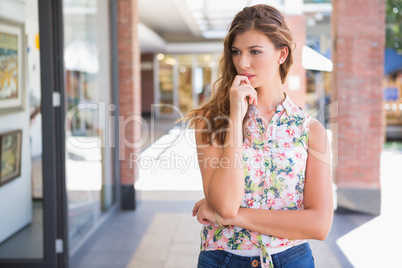 Thoughtful woman wearing blouse with floral pattern
