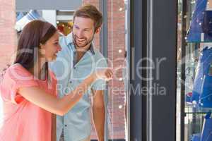 Young happy couple looking at a window