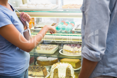 Young happy couple choosing cake