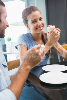Young happy couple eating cake