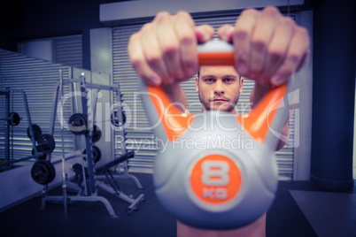 Muscular man lifting a kettlebell