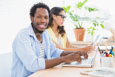 Smiling designer typing on keyboard