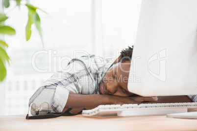 Tired casual businessman sleeping on keyboard