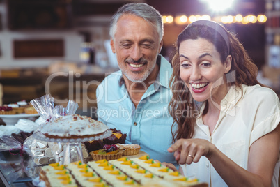 Happy couple pointing pastries