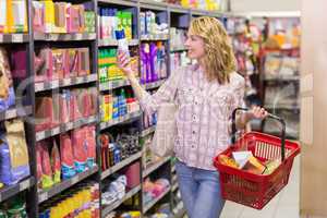 Smiling blonde pretty woman looking at product