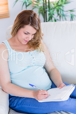 Pregnant woman writing down some notes