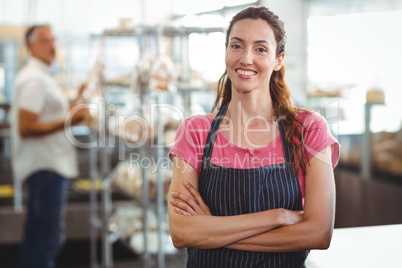 Smiling worker looking at camera with arm crossed