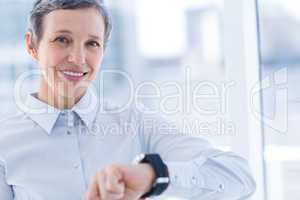 Smiling businesswoman using her smartwatch