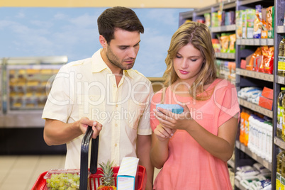 A bright couple buying products using shopping basket