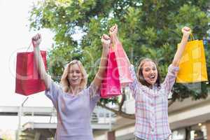 Smiling women friends holding shopping bags