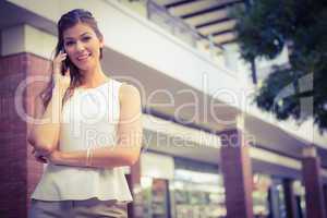 Portrait of smiling woman calling with smartphone and looking at