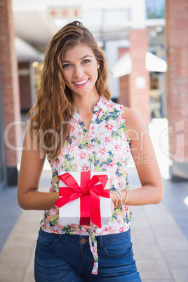 Portrait of smiling woman showing gift box to the camera
