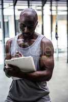 Young bodybuilder writing on a clipboard