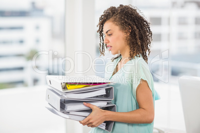 Businesswoman carrying a stack of folders