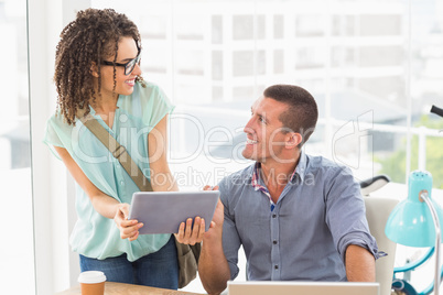 Business colleagues discussing over a tablet