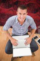 Smiling businessman typing on laptop