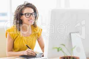 Creative young businesswoman drawing on graphic tablet