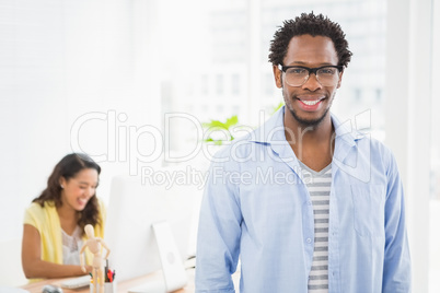 Smiling man posing in front of his colleague