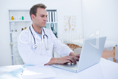 Focused doctor working with laptop