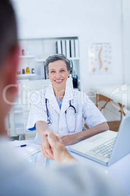 Female doctor hand shaking with patient