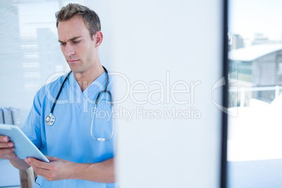 Attentive doctor watching his tablet