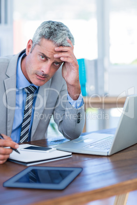 Depressed businessman trying to work