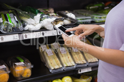 Woman reading her shopping list on smartphone