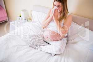 Pregnant woman blowing her nose