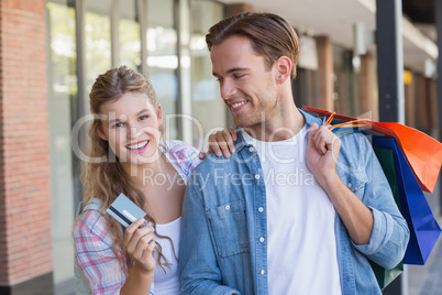 A happy couple showing their new credit card