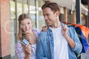 A happy couple showing their new credit card