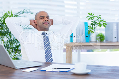 Relaxed businessman lying down in swivel chair