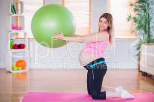 Pregnant woman holding exercise ball