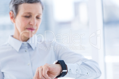 A businesswoman looking her smartwatch