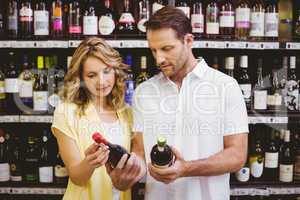 Casual couple looking at wine bottle