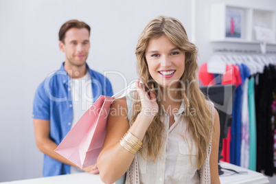 A pretty smiling happy blonde woman with a shopping bag