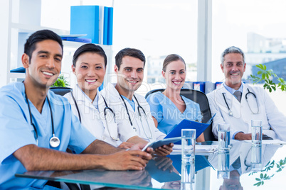 Happy doctors looking at camera while sitting at a table