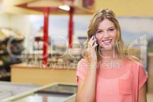 Portrait of a pretty smiling blonde woman buying products and ph