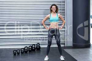 Standing muscular woman with hands on hips