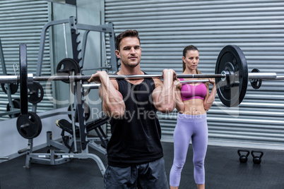 Muscular couple lifting weight together