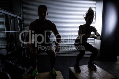 Muscular couple doing jumping squats