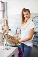 Portrait of smiling woman holding handbag and looking at camera