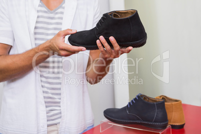 Young man holding a shoe