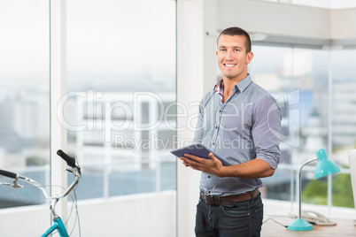 Smiling businessman using his tablet