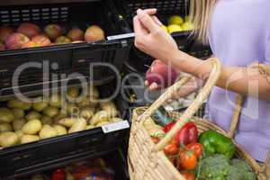 Smiling woman taking a fruit in the aisle
